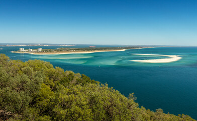 Beautiful landscape of the Tróia Peninsula in Portugal, with its beaches bathed by the blue and turquoise waters of the Atlantic Ocean, seen from the Serra da Arrábida on a summer day.