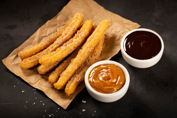 Traditional churros with sugar and chocolate sauce.