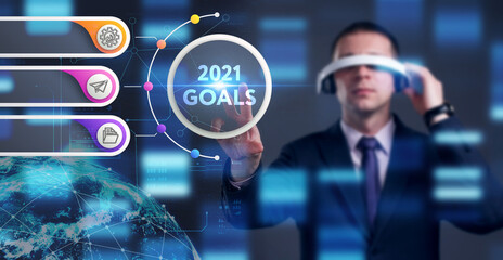 Business, Technology, Internet and network concept. Young businessman working on a virtual screen of the future and sees the inscription: 2021 goals