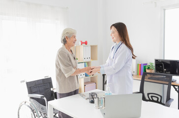 Asian doctor talk with old female patient about disease symptom, they holding hand together, elderly health check up, happiness hospital, hand in hand