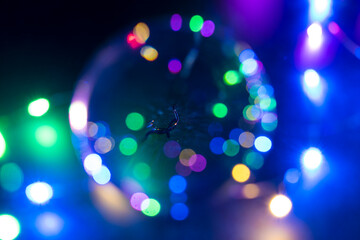 Blurry background of neon color LED lights reflected in glass orb