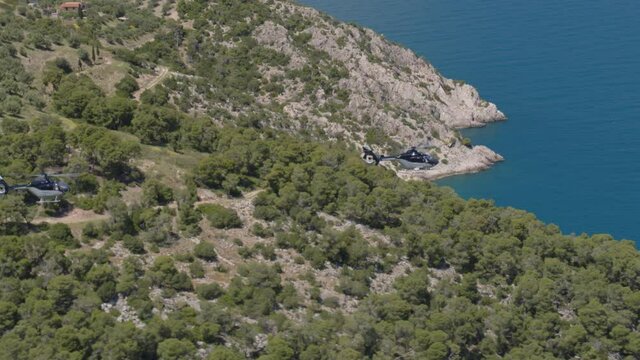 Two Private Helicopters Flying Over Mountains and Towards Ionian Sea in Greece