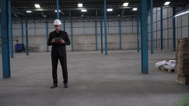 warehouse worker pulling a pallet truck parcel moving to dispatch . manager checking list with digital tablet  in distribution warehouse. supervisor controlling stock and inspection inventory