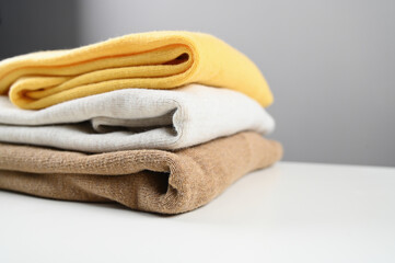 Stack of clothes with empty copy space. Brown, grey and yellow color tone