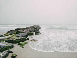 Rocky pier in pacific ocean. Rocky shore of Long Beach New York. 