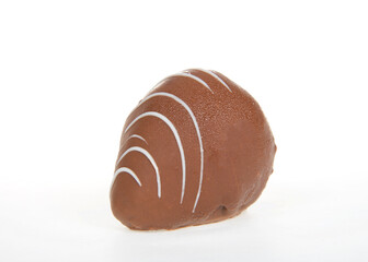 Close up on giant strawberry dipped completely in milk chocolate, drizzled with contrasting white chocolate. Isolated on white.