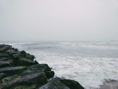 Rocky pier in pacific ocean. Rocky shore of Long Beach New York. 