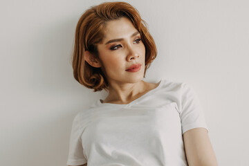 Cool looks of an Asian woman in a t-shirt and jeans relax in her apartment room.