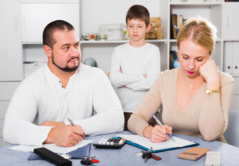 Obraz premium Portrait of family working with papers at home, worried about debts on bills