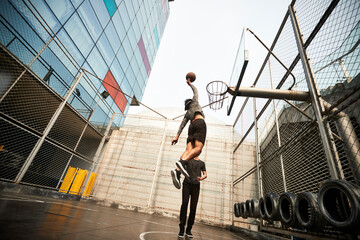 two young asian men playing basketball outdoors