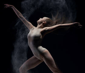 Athletic dancer in cloud of powder on the scene