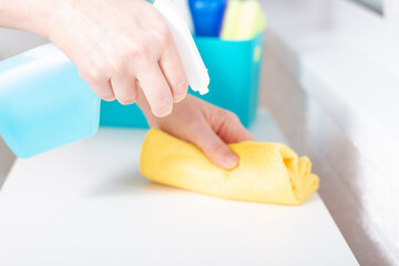 Cleaning service with blue spray and wipe. Woman using detergent and disinfectants . Goods for cleaning. Clean rag in household care.