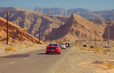 Cars passing in the scenic desert road on the Jebel Jais mountain in the UAE 