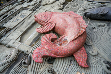 Stone carving of carp playing in water in traditional Chinese culture