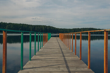 Fototapeta premium fishing bridge by the river. docks for boats on the lake. water and transport