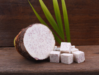 Taro root on old wooden background.