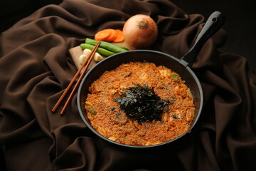 갈색 배경에 김이 올라가 있는 한국식 볶음밥 Korean fried rice with seaweed on top of brown background.