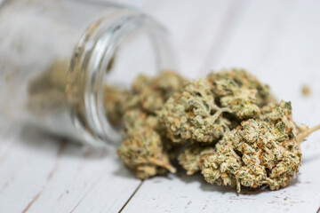 Trimmed marijuana buds coming out of clear glass container. from medical cannabis store in 