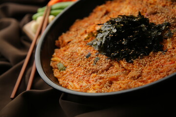 갈색 배경에 김이 올라가 있는 한국식 볶음밥 Korean fried rice with seaweed on top of brown background.