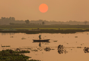 River with fishing boat and rural landscape at dusk at West Bengal, India