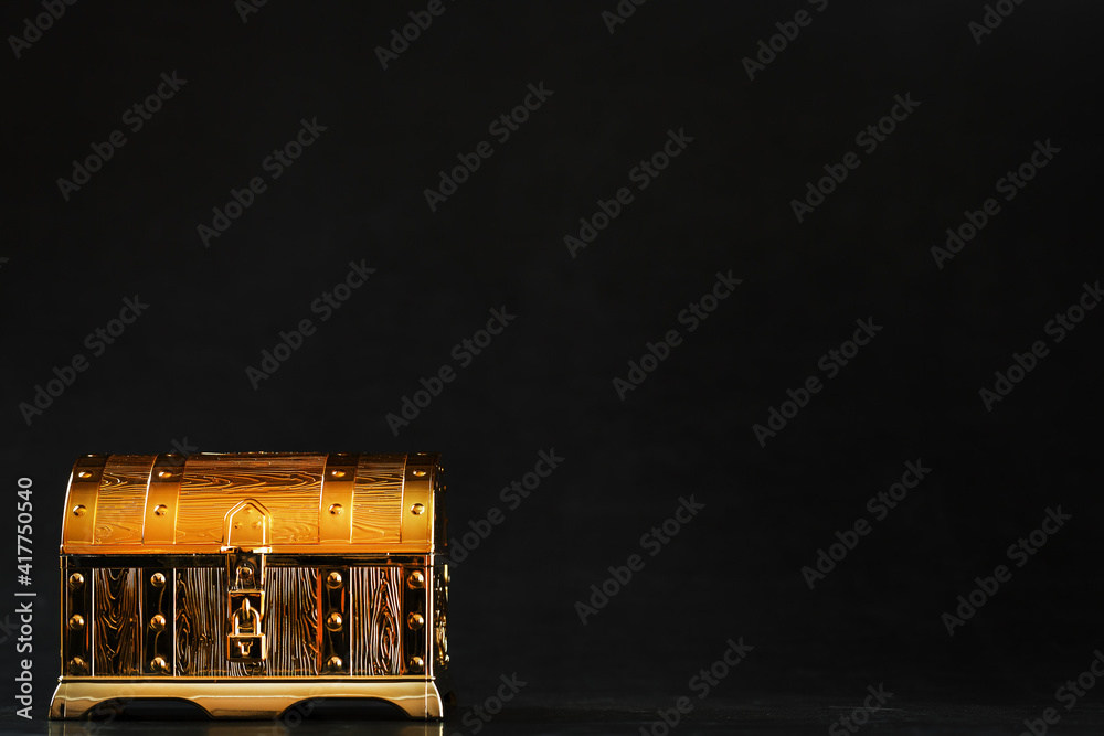 Wall mural a chest made of gold with jewels on a black background.