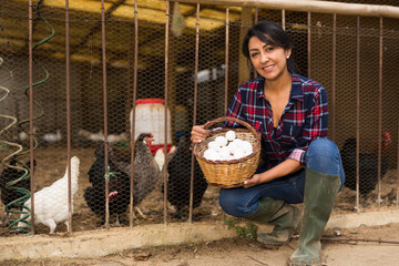 Portrait of woman farmer with a basket of chicken eggs © JackF