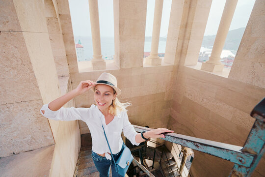 Traveling by Croatia. Young traveling woman enjoying old town Split view, of ancient architecture in Diocletian tower.