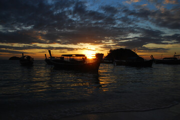 Fishing boat silhouette at sunset on the ocean.