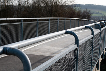 a concrete footbridge with a metal railing