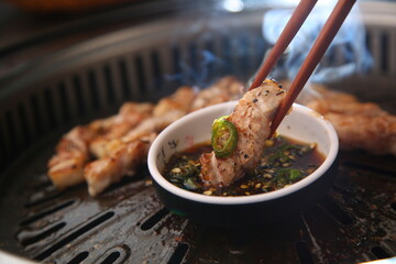 밑반찬과 생돼지고기가 있는 상차림 Table set with side dishes and raw pork