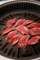 The beef ribs are being cooked on a black grill 검은색 불판에 소고기 갈비살이 익어가고 있는 모습