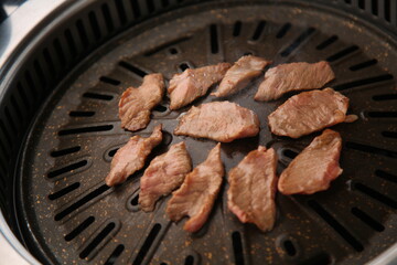 The beef ribs are being cooked on a black grill 검은색 불판에 소고기 갈비살이 익어가고 있는 모습