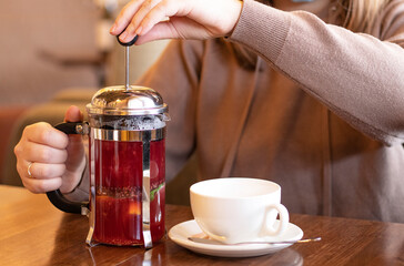 Girl prepares tea in the French press