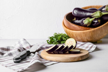 Composition with fresh eggplants on light background