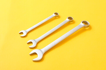 Metal wrenches on color background