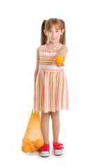 Cute little girl and bag with oranges on white background