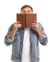 Fototapeta premium Surprised young man with book on white background