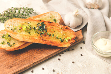 Toasted bread and garlic on light background, closeup