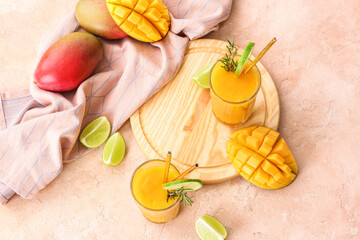 Glasses with tasty mango smoothie on color background