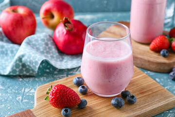 Glass of tasty berry smoothie on color background