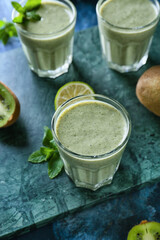 Glasses of tasty kiwi smoothie on color background