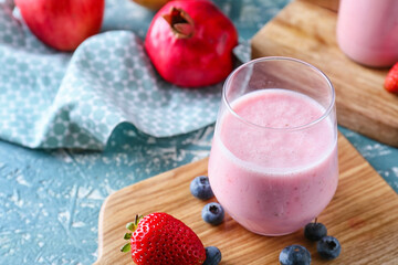Glass of tasty berry smoothie on color background