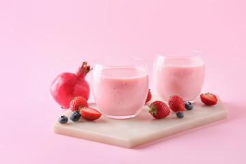 Glasses of tasty berry smoothie on color background