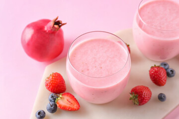 Glasses of tasty berry smoothie on color background