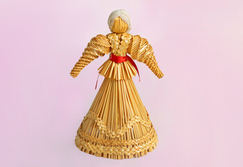 Straw doll traditional toy of the Slovenian countries on a pink isolated background. Symbol of...