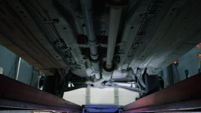 This video shows the underside of a car that is being repaired in a garage.