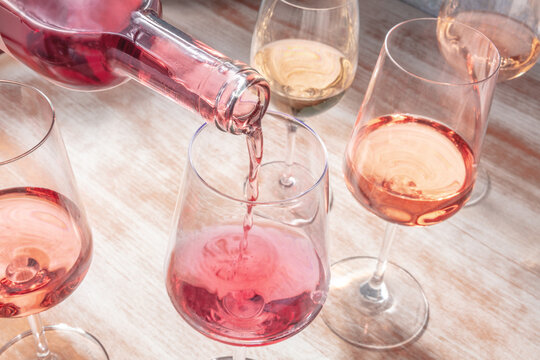 Rose wine poured into a glass, a wine tasting or a party