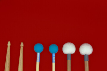 Percussion mallets set on a red background, with space box on the bottom.