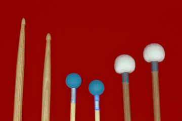 Percussion mallets set on a red background.