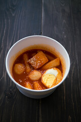 Stir-fried Rice Cake Tteok-bokki in a takeaway container. Korean food delivery.